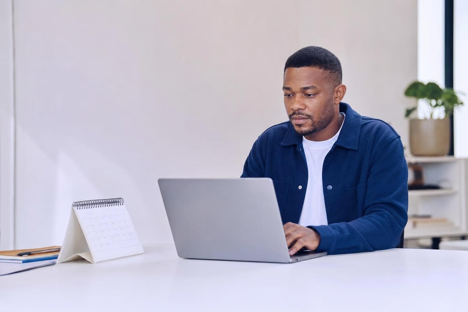 An owner calmly clearing her inbox on a laptop with a tidy calendar visible.
