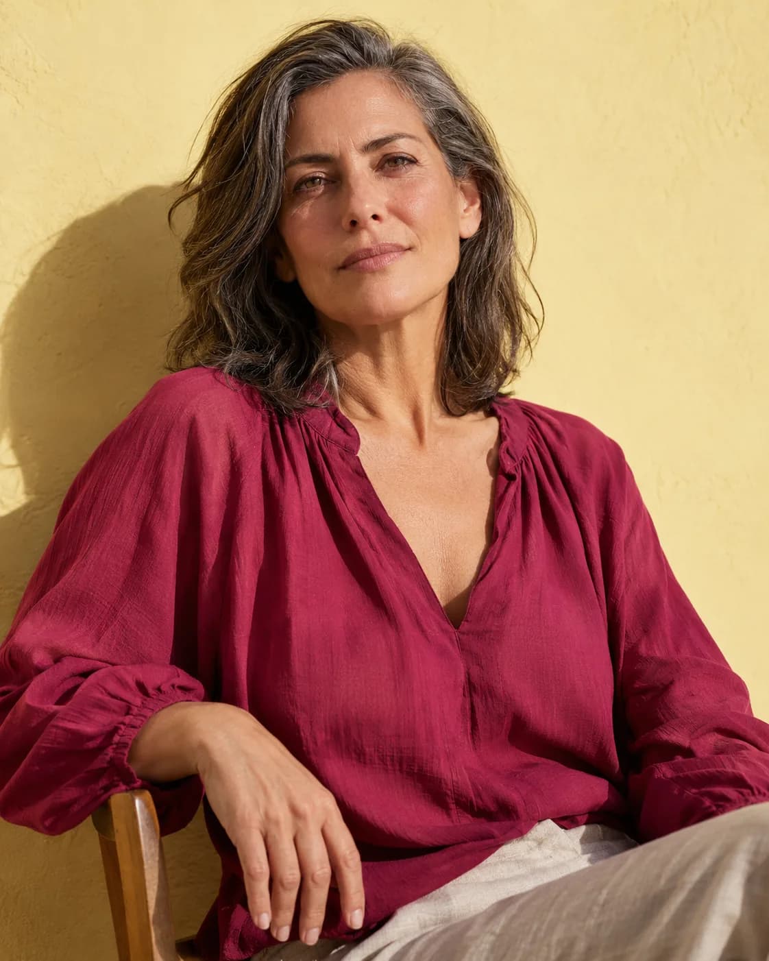 A midlife woman looking directly toward the camera in warm afternoon light