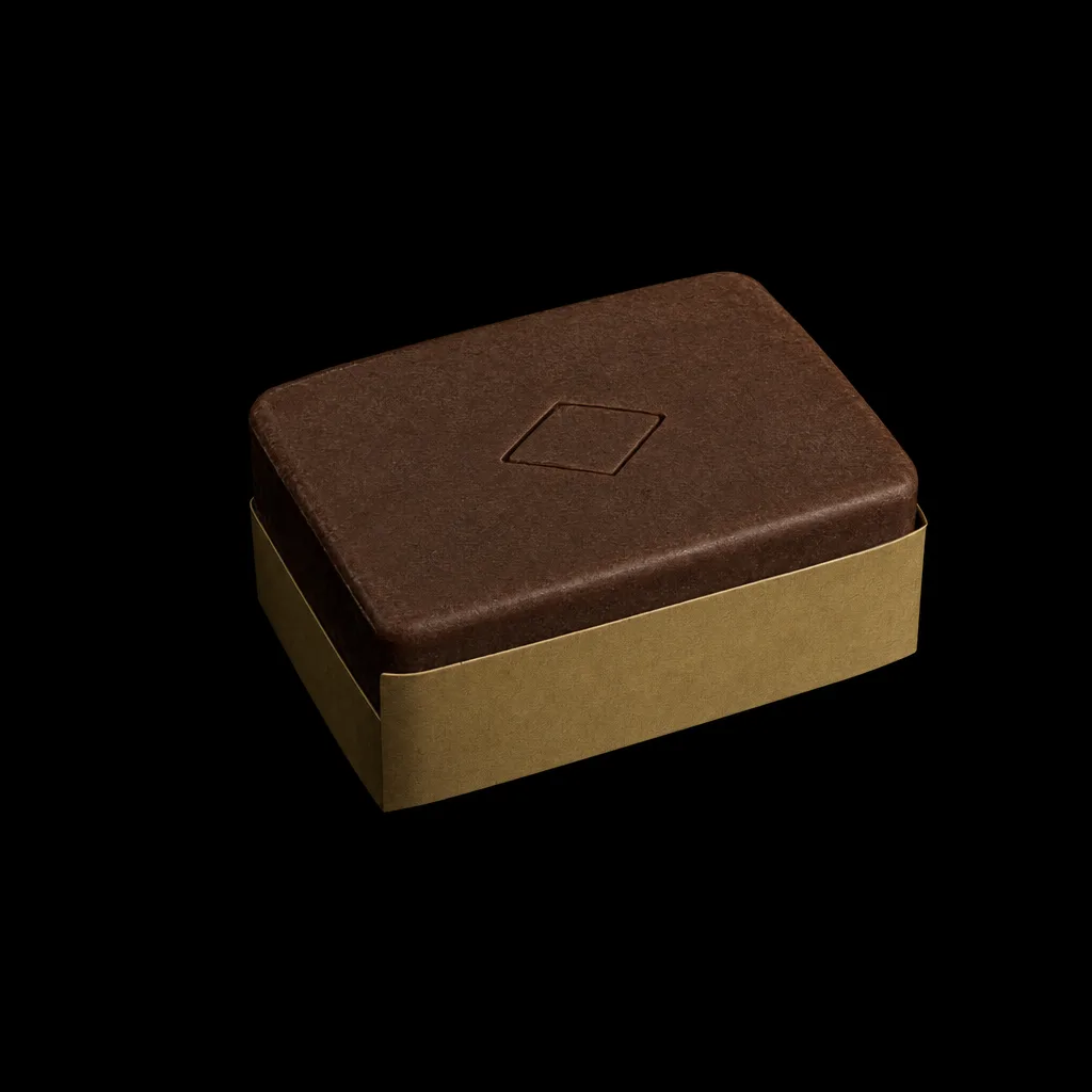 Espresso-brown shampoo bar on its brass paper band