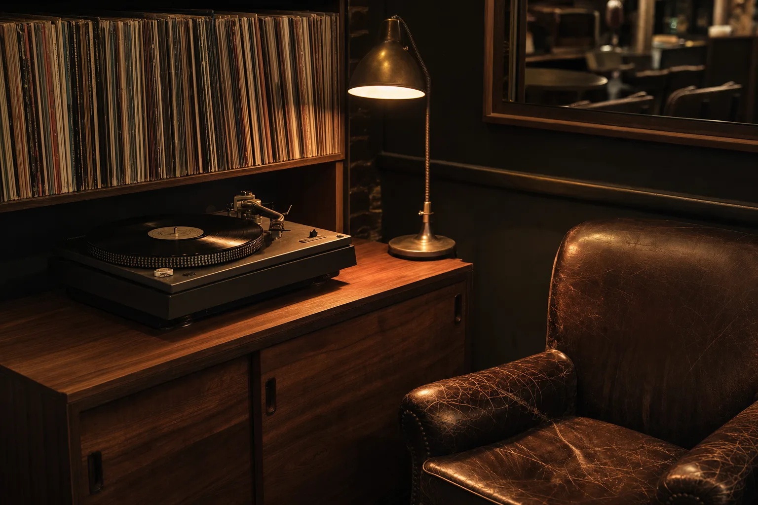 Turntable and shelved vinyl by a worn leather armchair