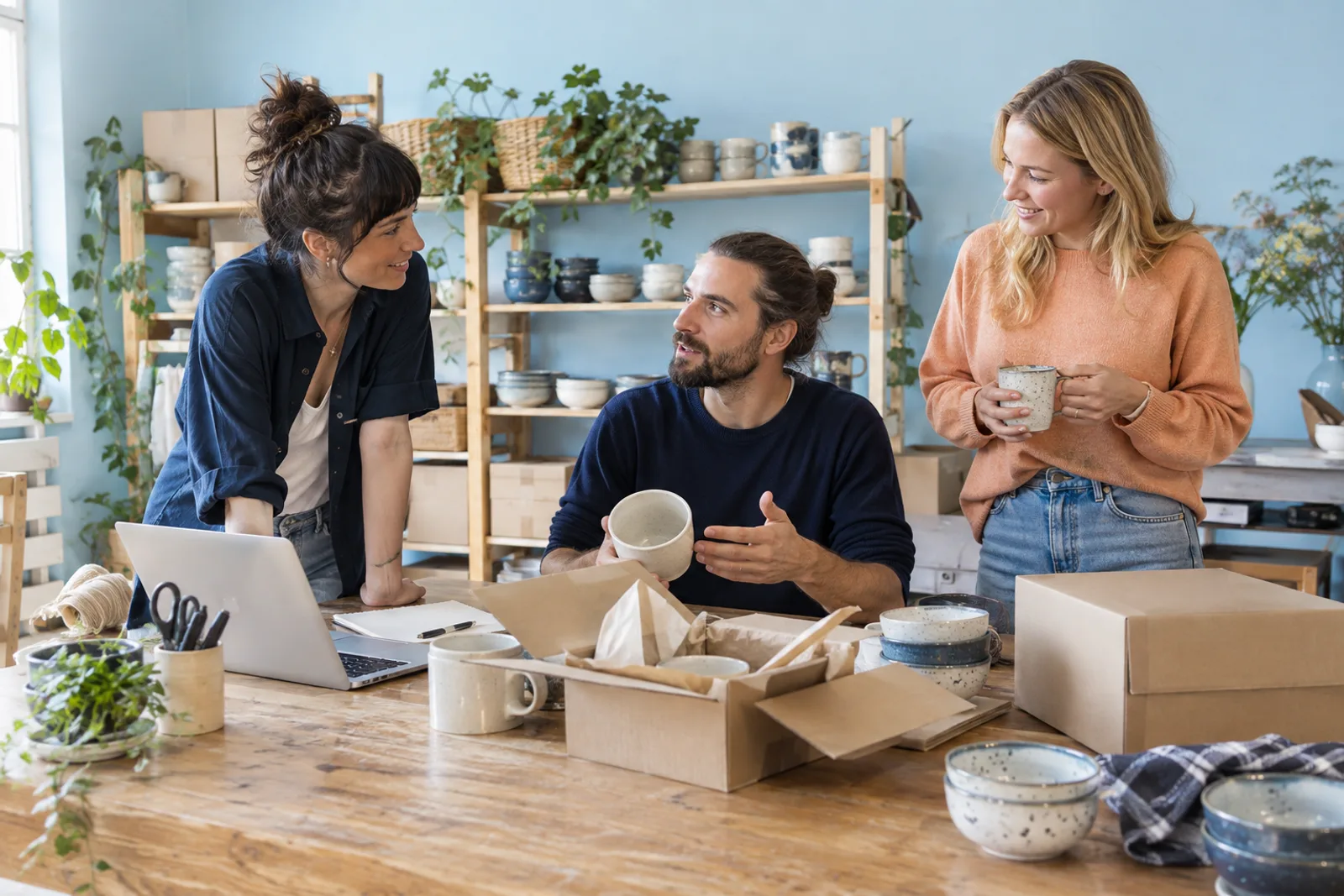 Three people discussing the work behind an online shop.