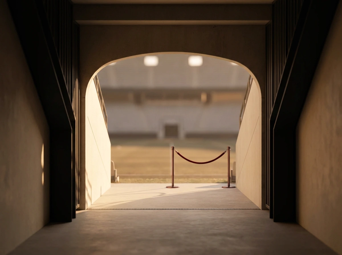 A stadium tunnel opening onto a floodlit field at dusk.