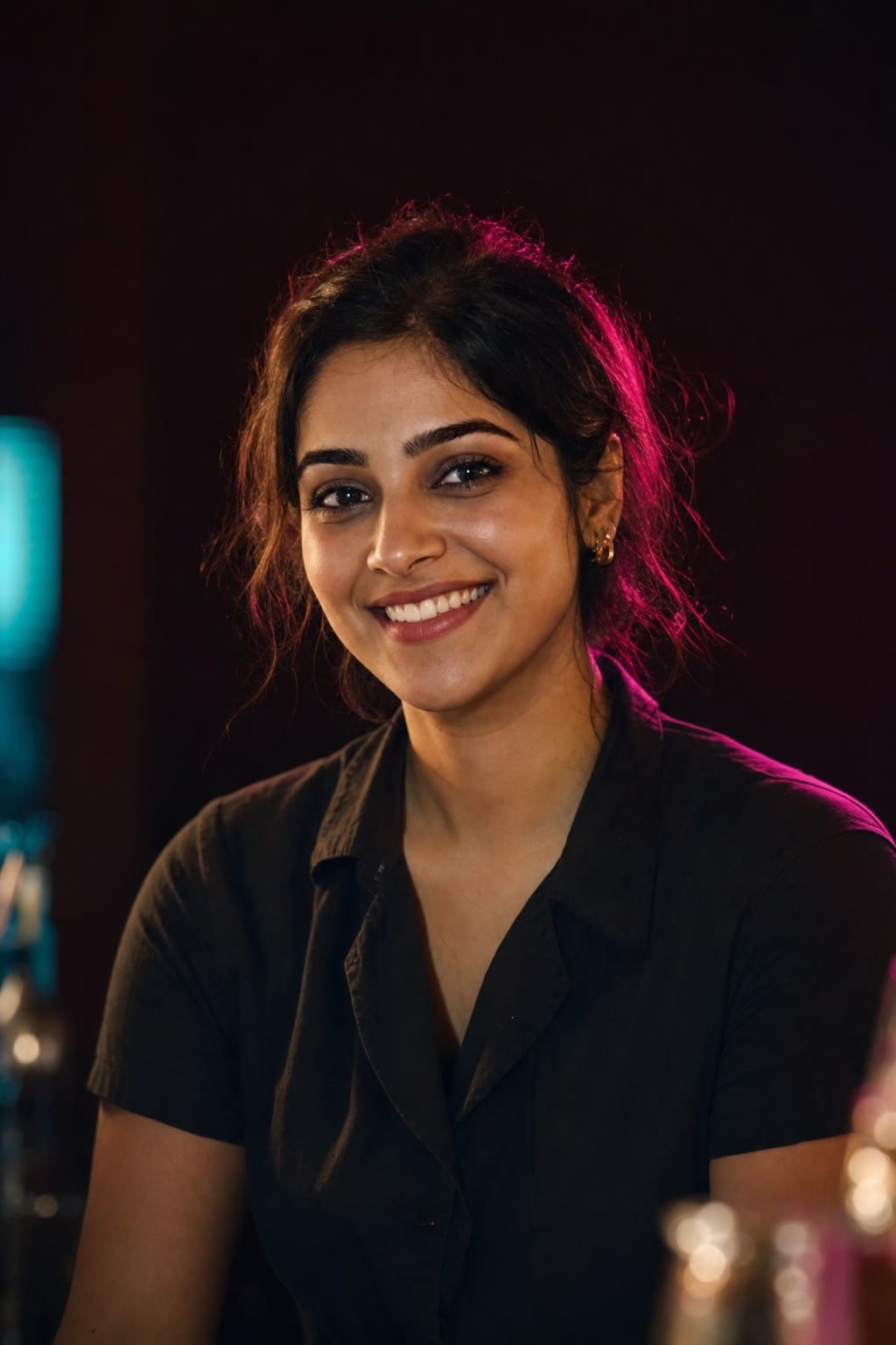 Priya Nair, bartender, smiling in the warm dark of the bar